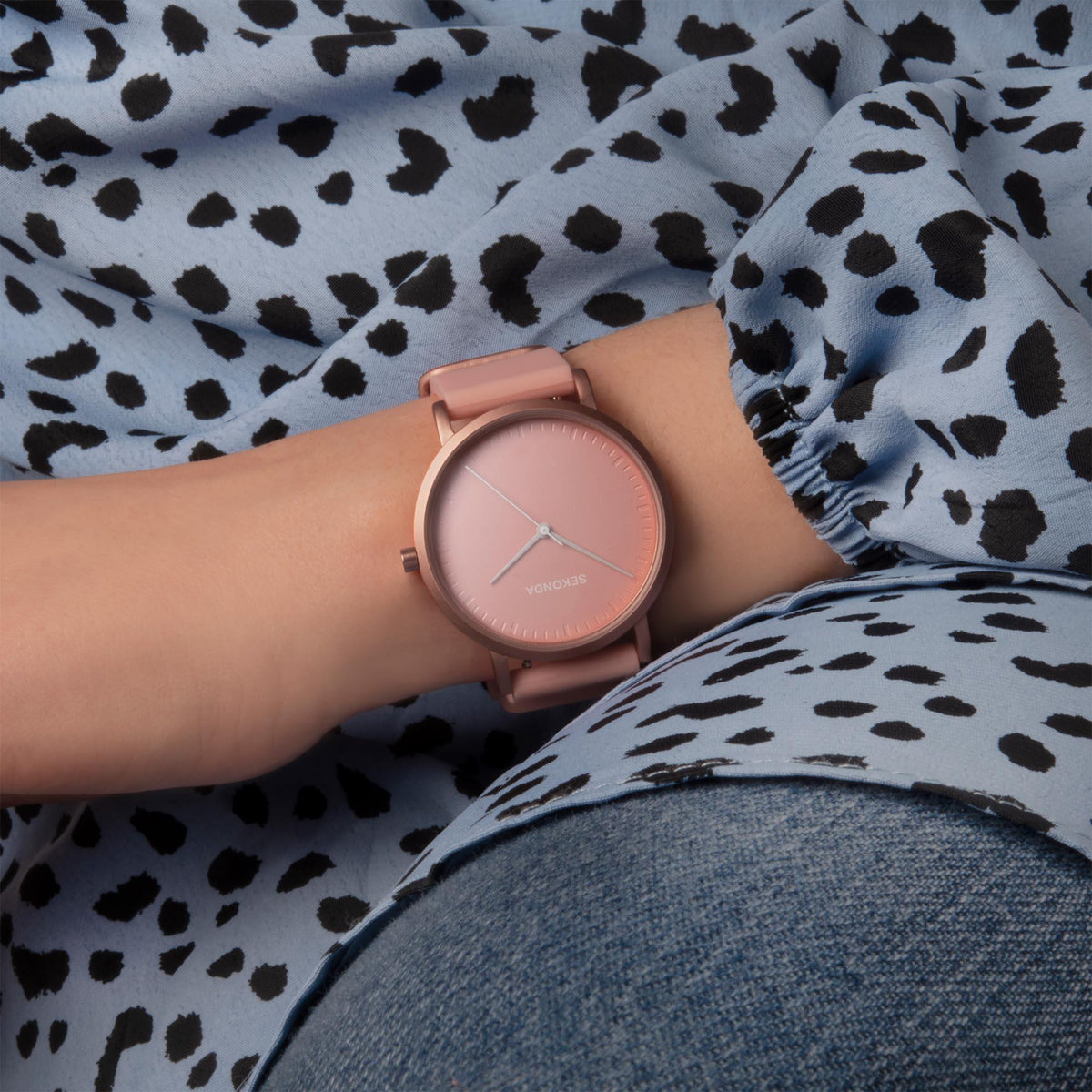 Rose-gold tone quartz watch with pink dial and pink silicone strap on wrist