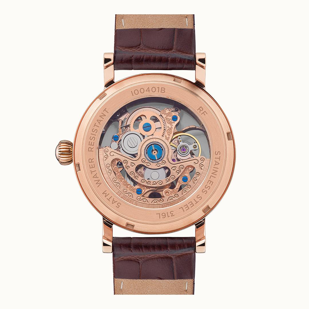 Automatic watch case back with engraved markings and visible gears; brown leather strap