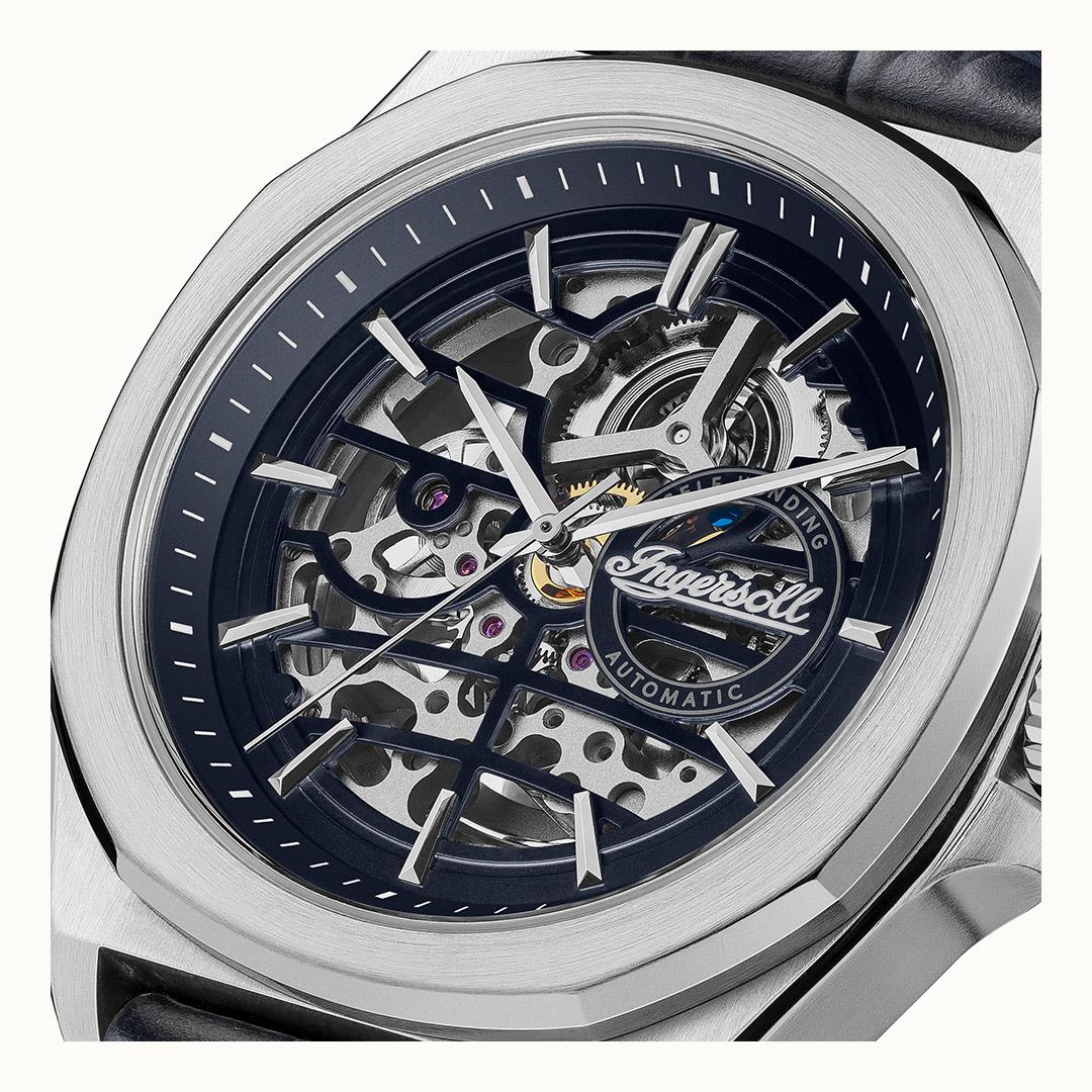 Automatic skeleton wristwatch with navy dial, exposed gears, and blue leather strap