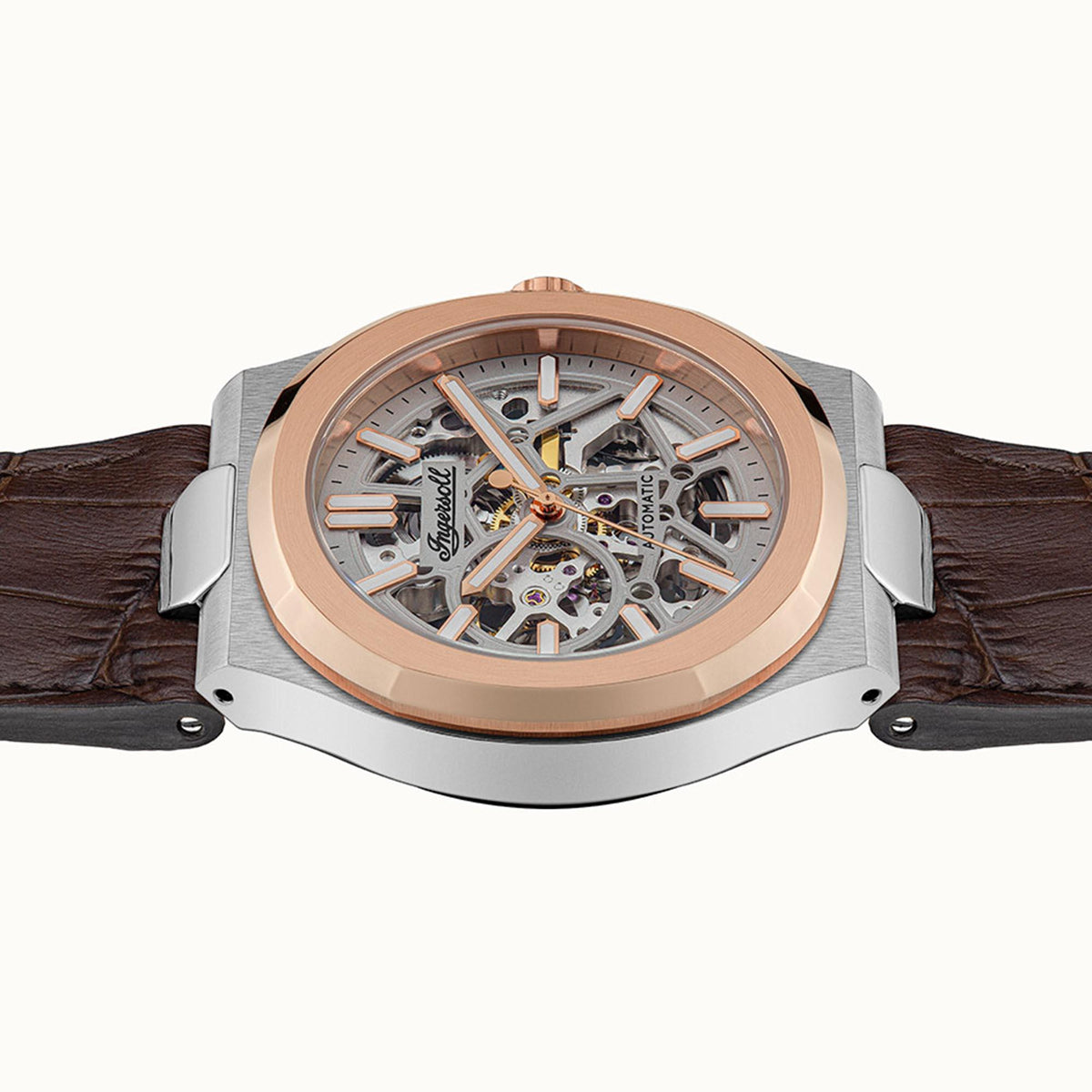 Men's automatic skeleton watch with exposed silver movement, rose-gold bezel, brown leather strap