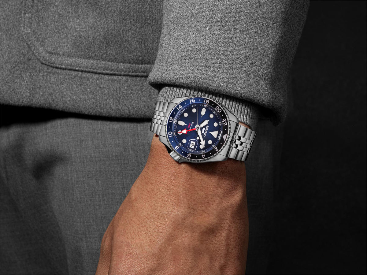 Stainless steel GMT automatic watch on wrist with blue dial and ridged bezel