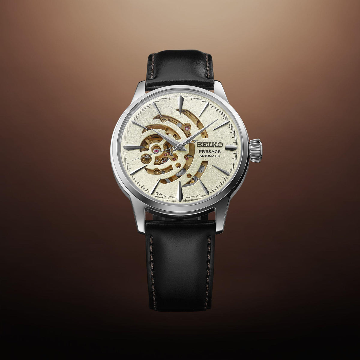 Seiko watch with black leather strap on a gradient brown background