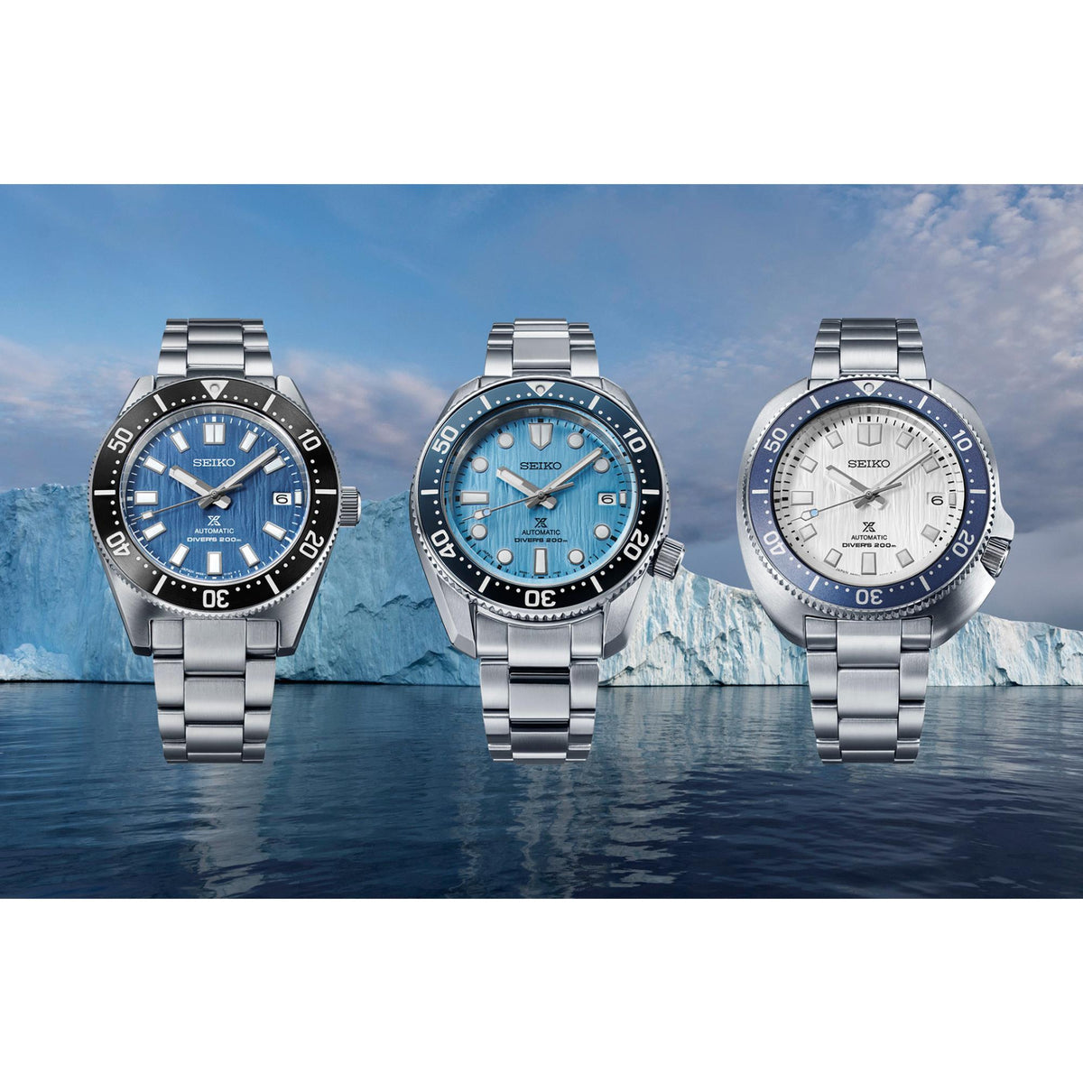 Three men’s stainless steel dive watches with blue bezels and steel link bracelets.