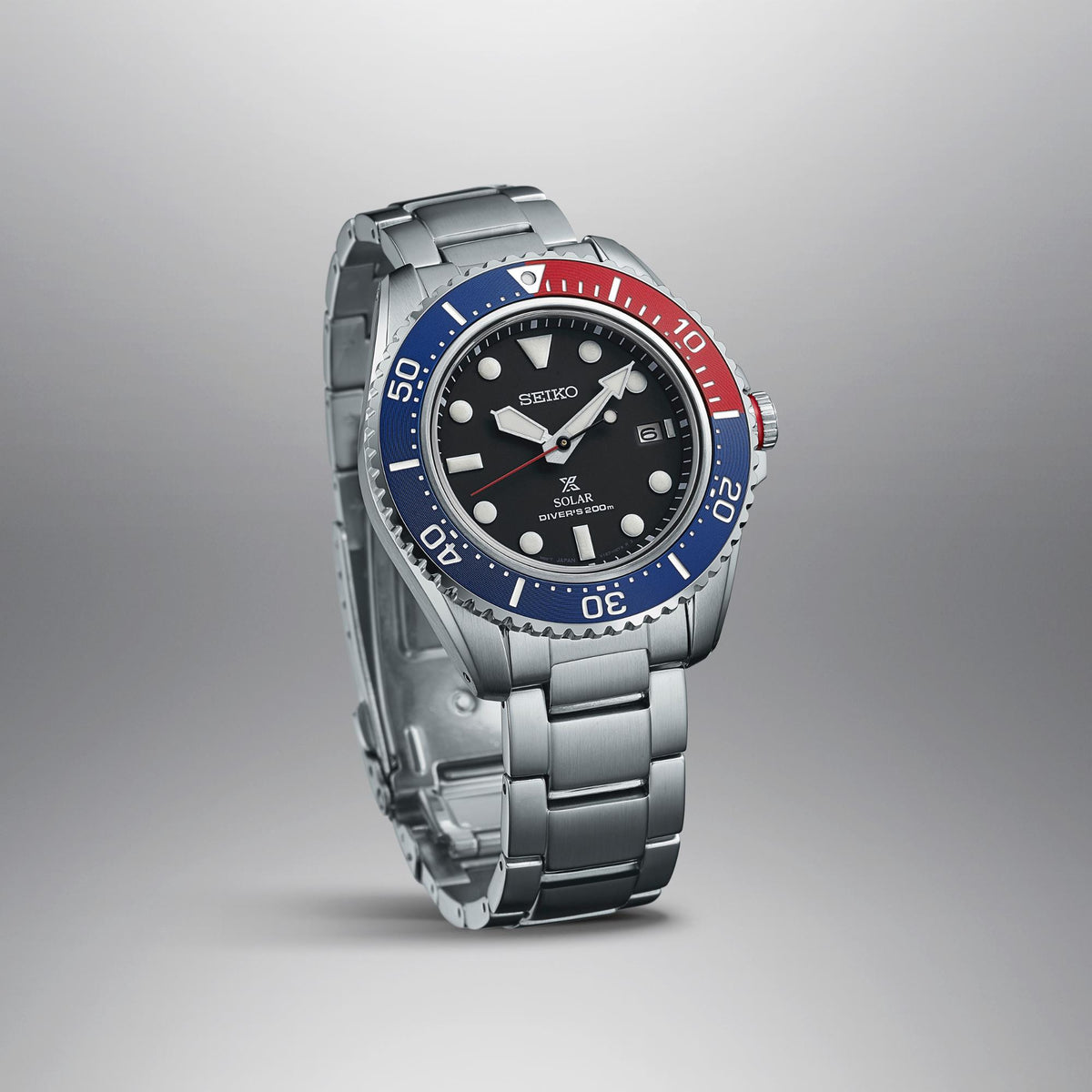 Men's stainless steel diver watch angled view, black dial and blue-red rotating bezel