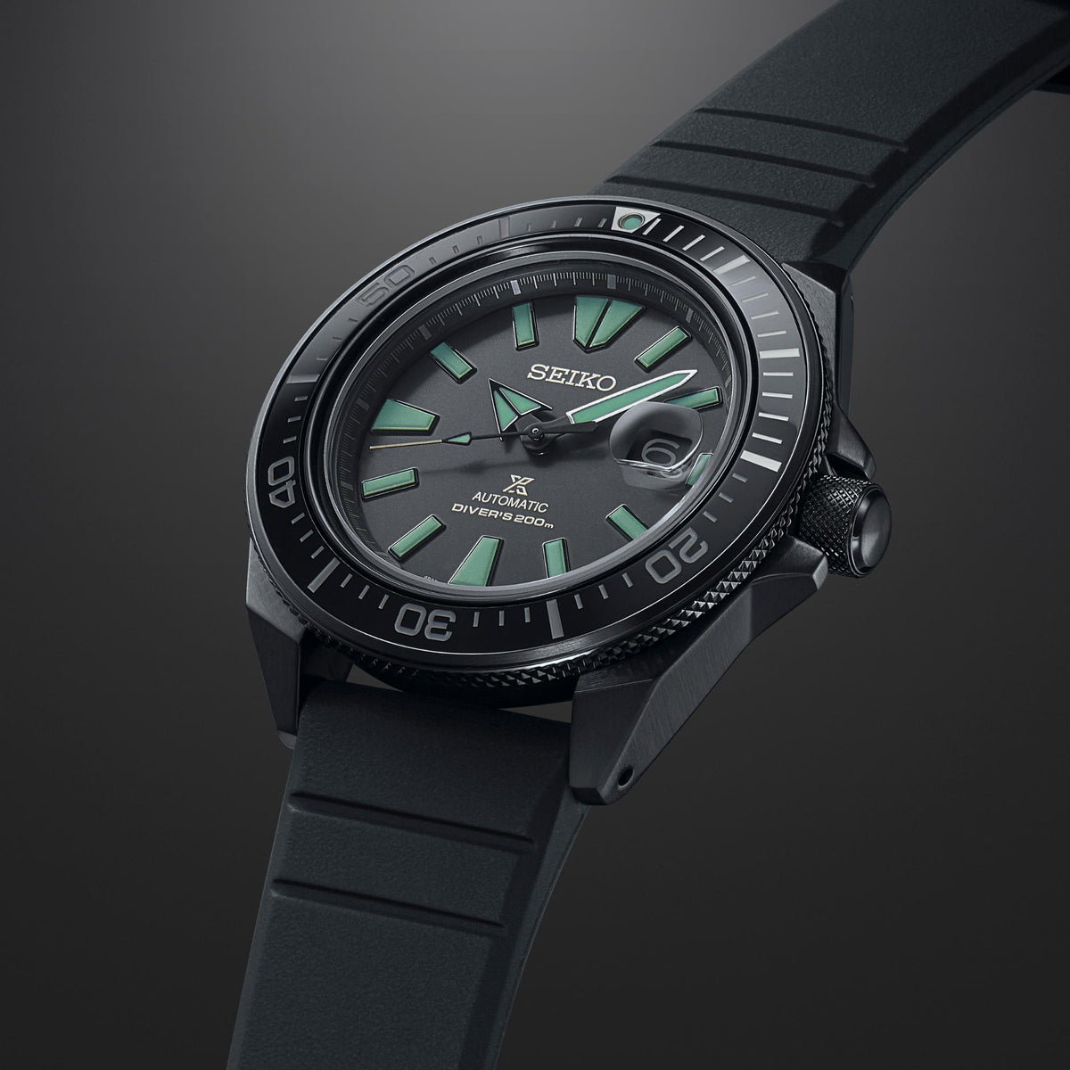 Close angled Seiko diver watch with black bezel and strap, green dial details