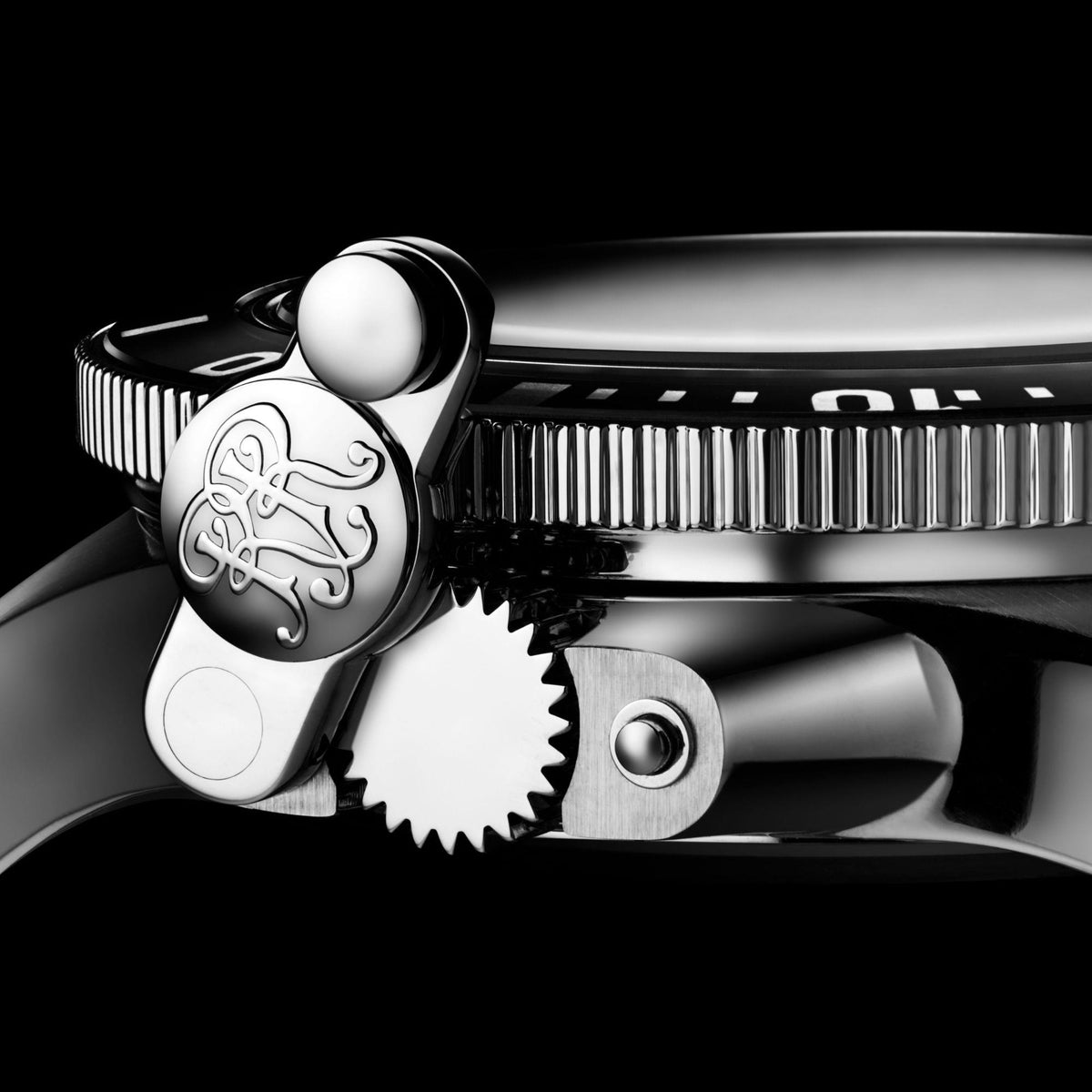 Stainless steel watch detail with textured bezel, crown knob and gear-like rim