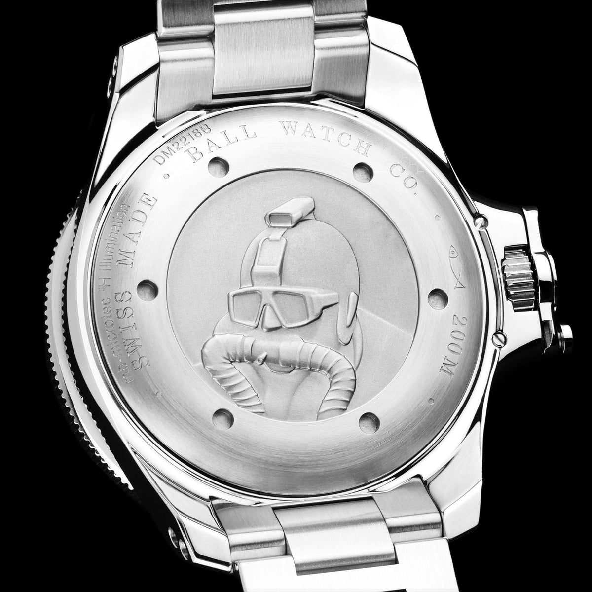 Stainless steel caseback with engraved hydrocarbon scene and screw-down bezel