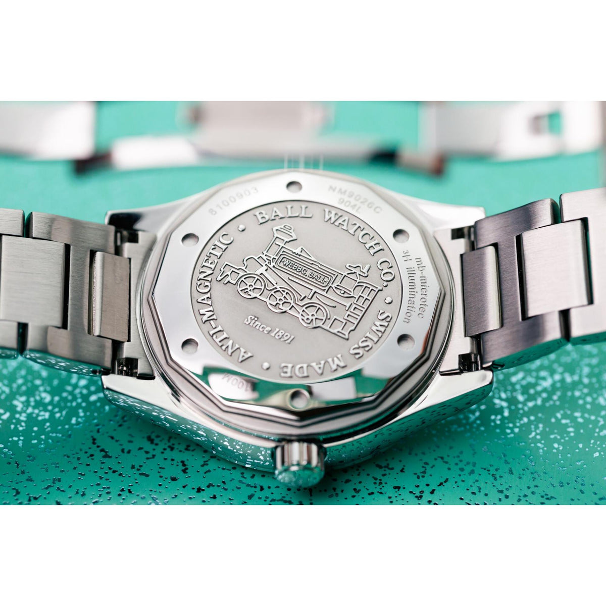 Stainless steel men's watch case back with engraved details and metal link bracelet