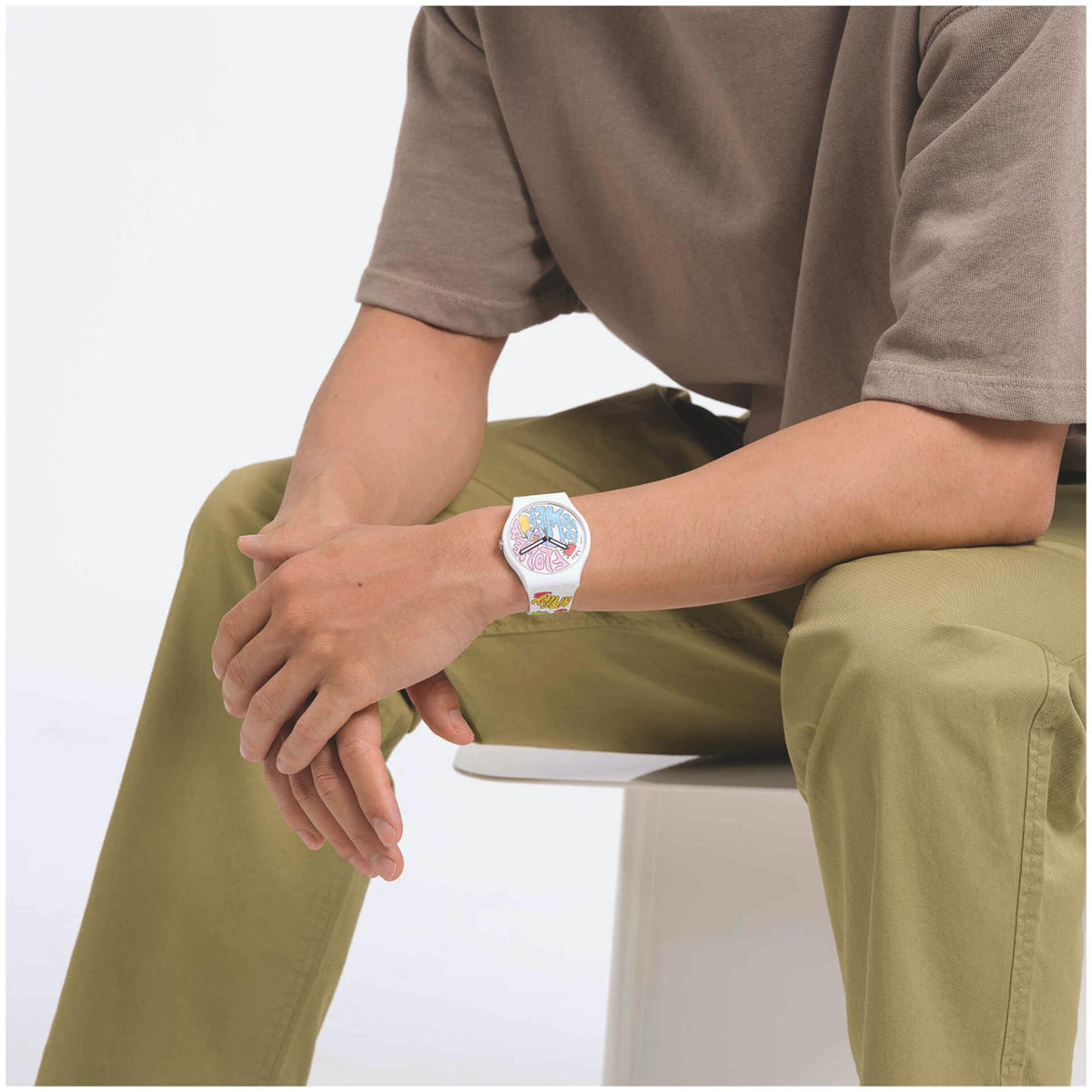 Swatch silicone quartz watch on wrist, multicolour dial with patterned strap
