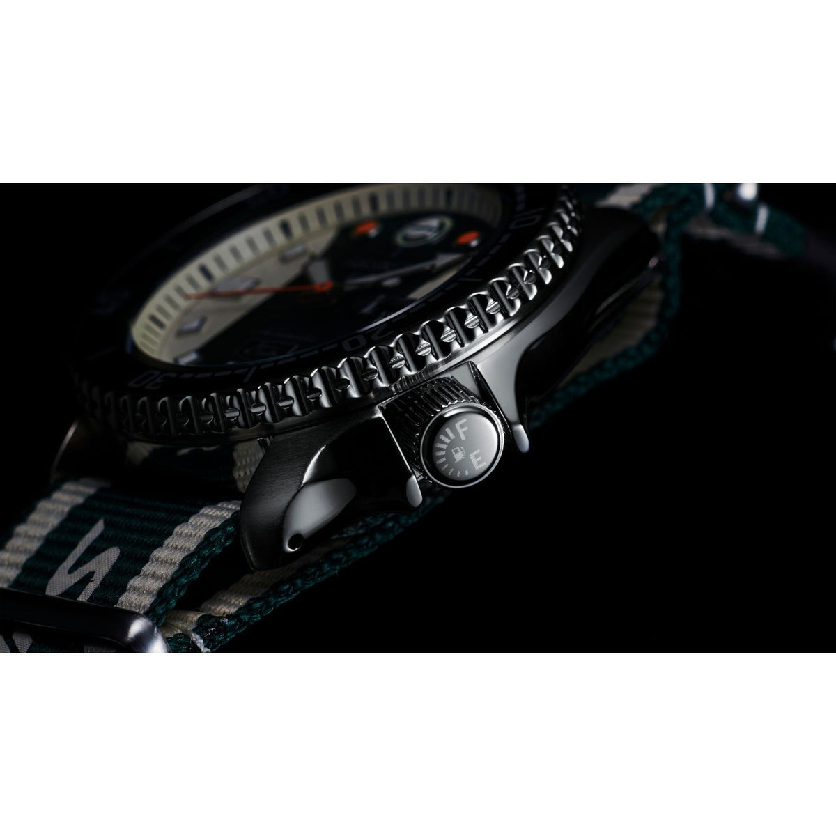 Bezel and crown close-up on stainless watch case with striped NATO strap