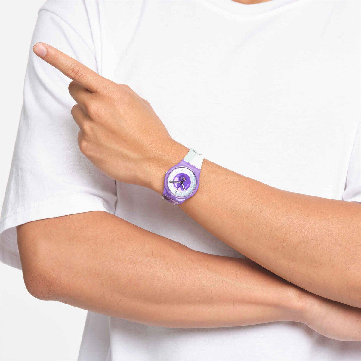 Person wearing a purple dial wristwatch with white strap, shown on the forearm.