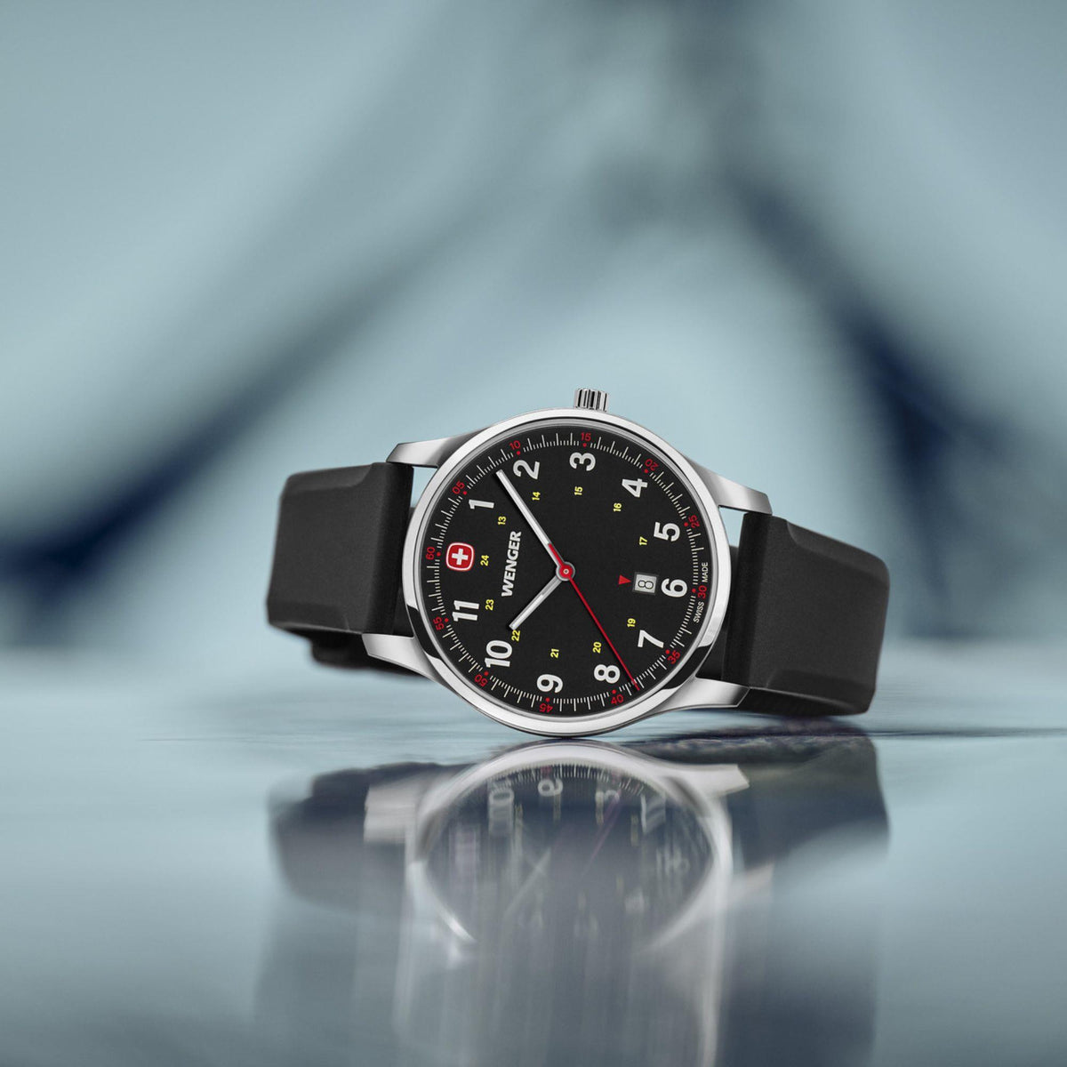 Men's analog wristwatch angled close-up, black dial with red logo and markers