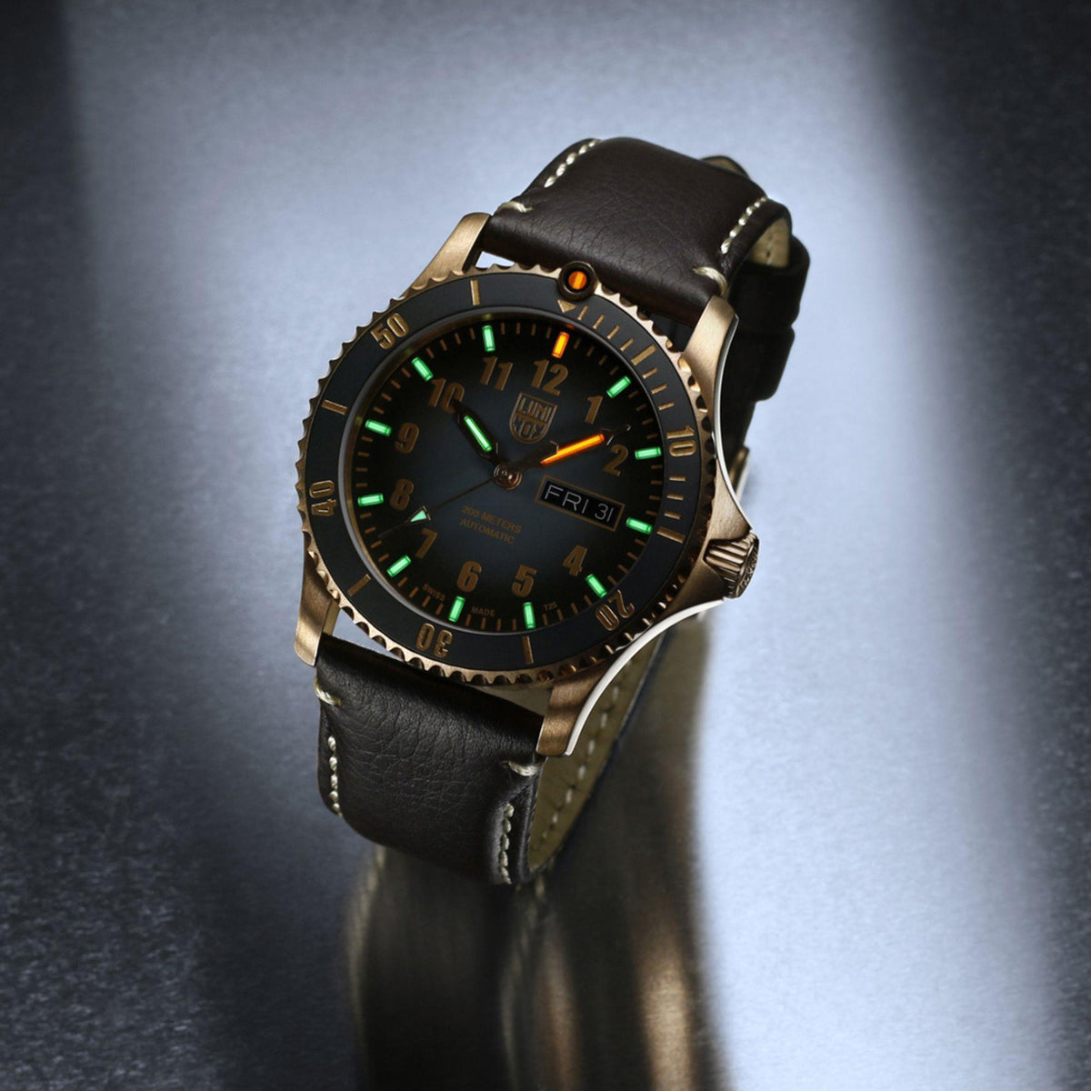 Men's automatic watch in gold-tone case, black dial with green lume, brown leather strap