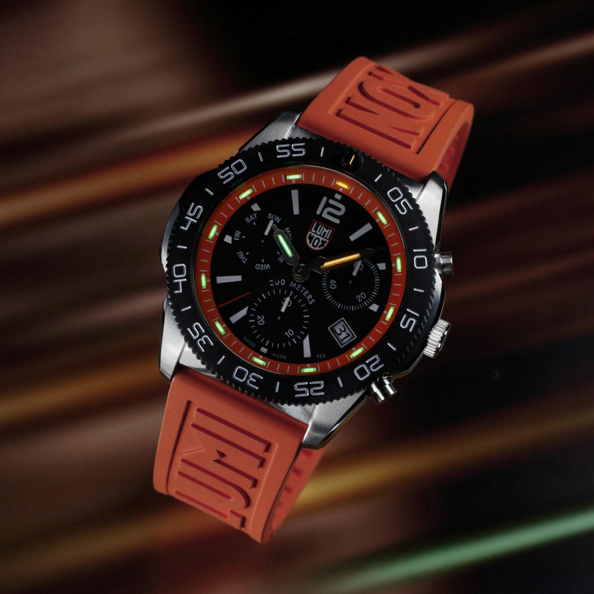 Luminox diver chronograph watch with orange rubber strap, black dial, and green accents