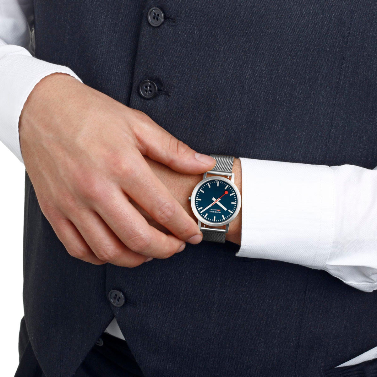Mondaine blue dial watch on wrist with silver mesh bracelet