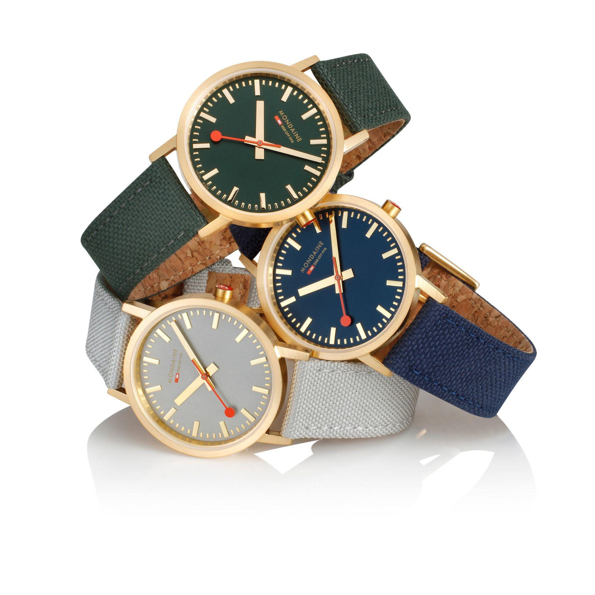 Three gold-tone watches on straps, featuring green, blue, and gray dials
