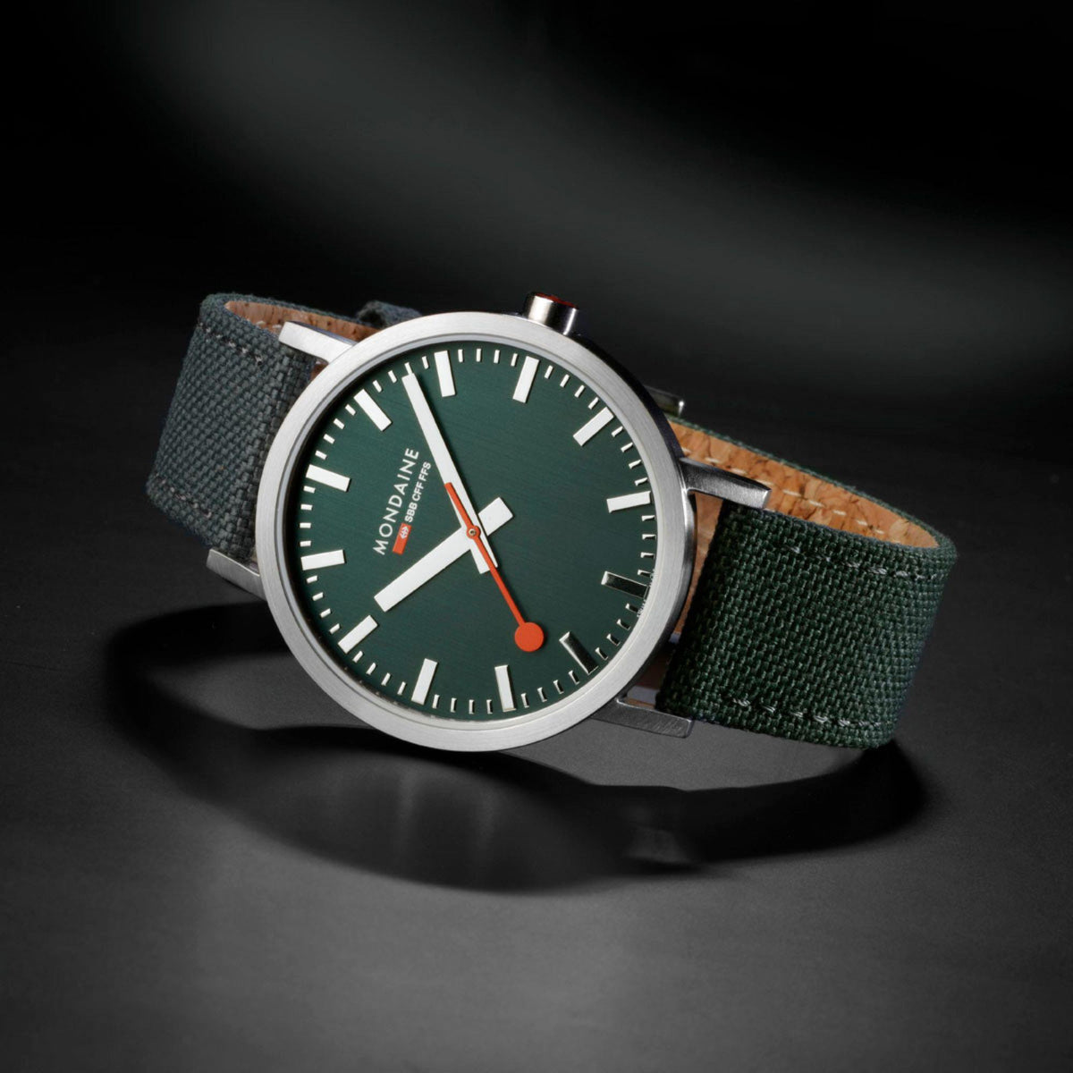 Mondaine green dial wristwatch with silver case and green fabric strap