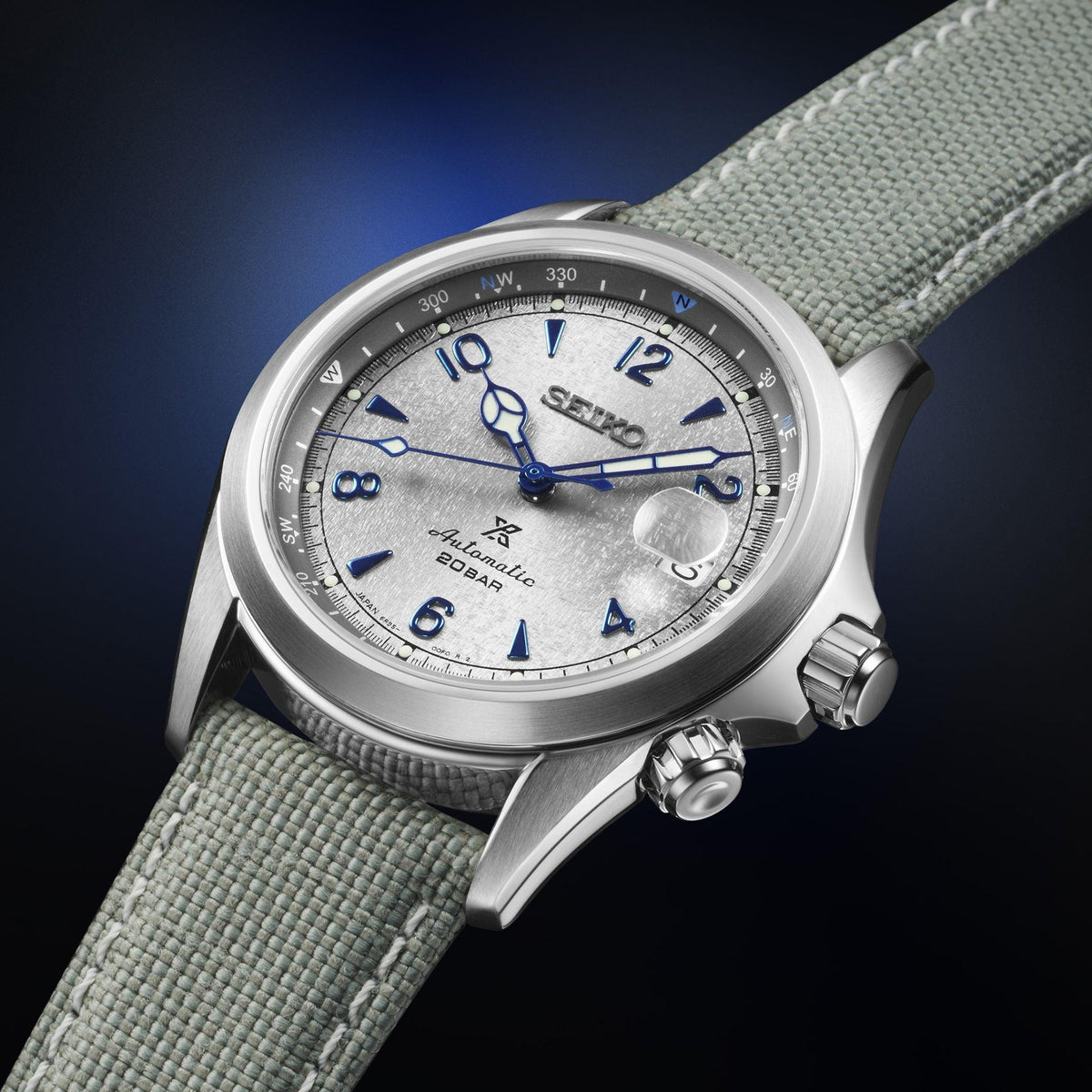 Men's stainless steel watch close-up on grey textile strap, grey dial with blue markers