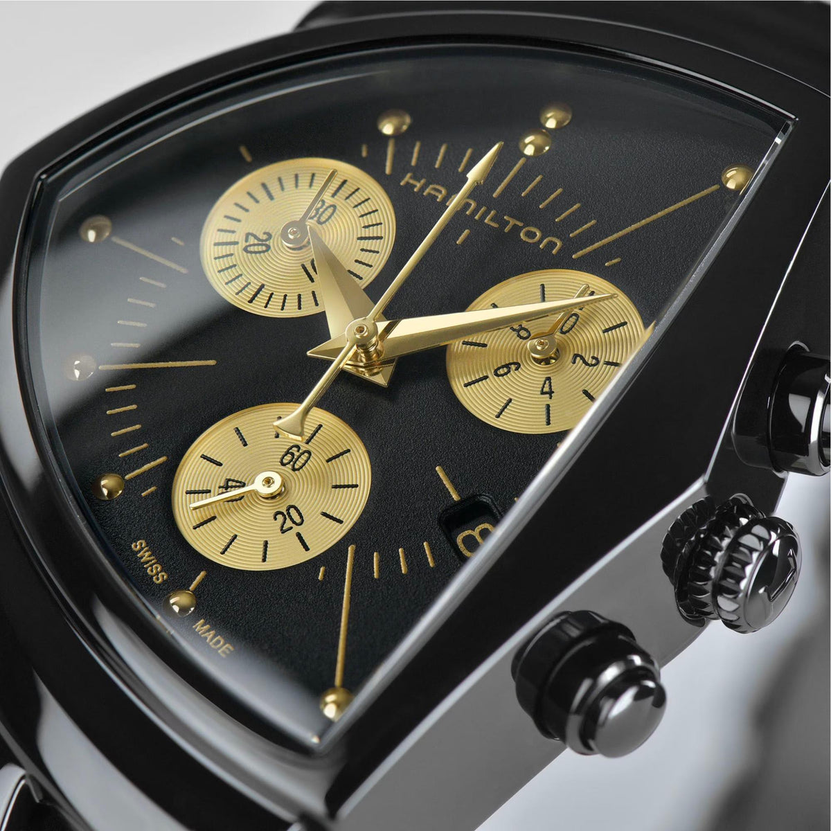 Hamilton Ventura chronograph watch close-up of black dial with gold hands and pushers