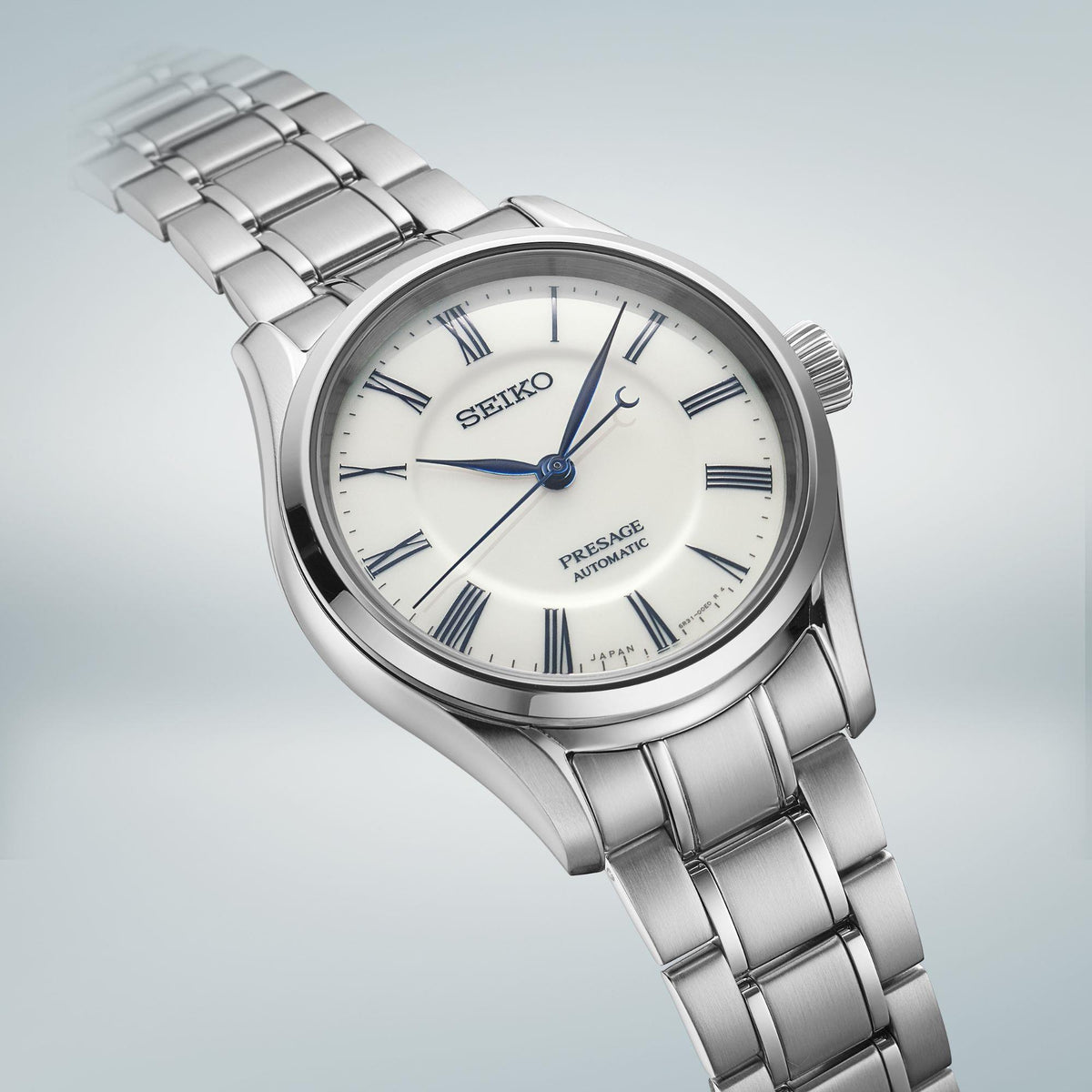 Angled men's stainless steel wristwatch with white dial, blue hands, and linked bracelet