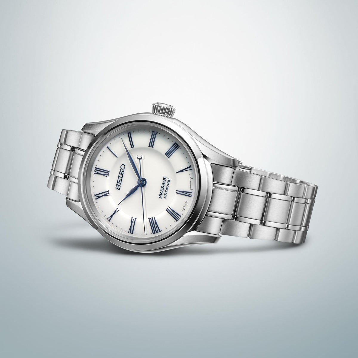 Side-profile men's stainless steel wristwatch with white dial and blue Roman numerals