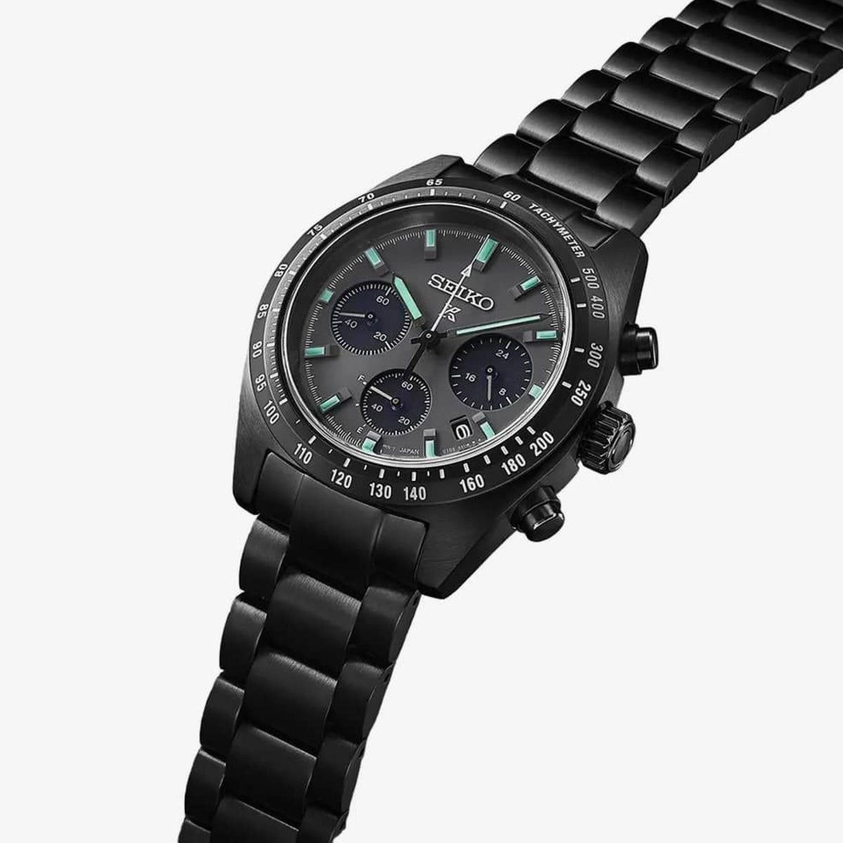 Black chronograph watch with tachymeter bezel and steel bracelet, turquoise accents