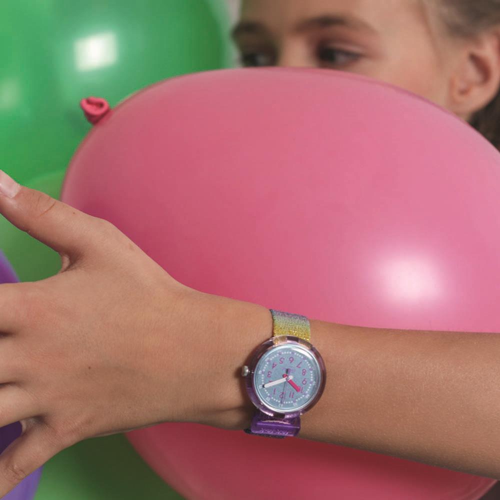 Girls' rainbow quartz wristwatch on arm, purple case and sparkling multicolor band