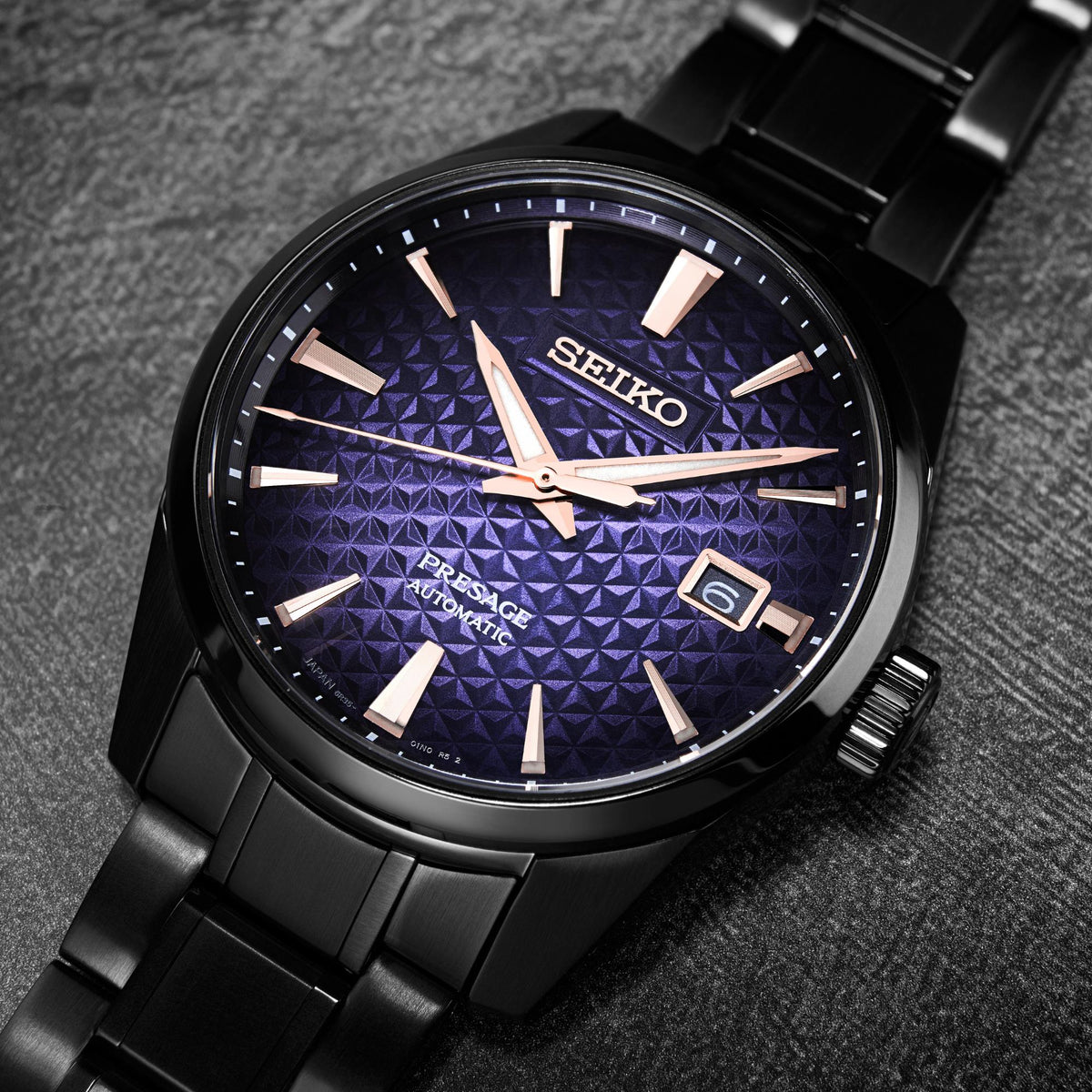 Men's blue textured dial watch close-up with rose-gold SEIKO logo and hour markers