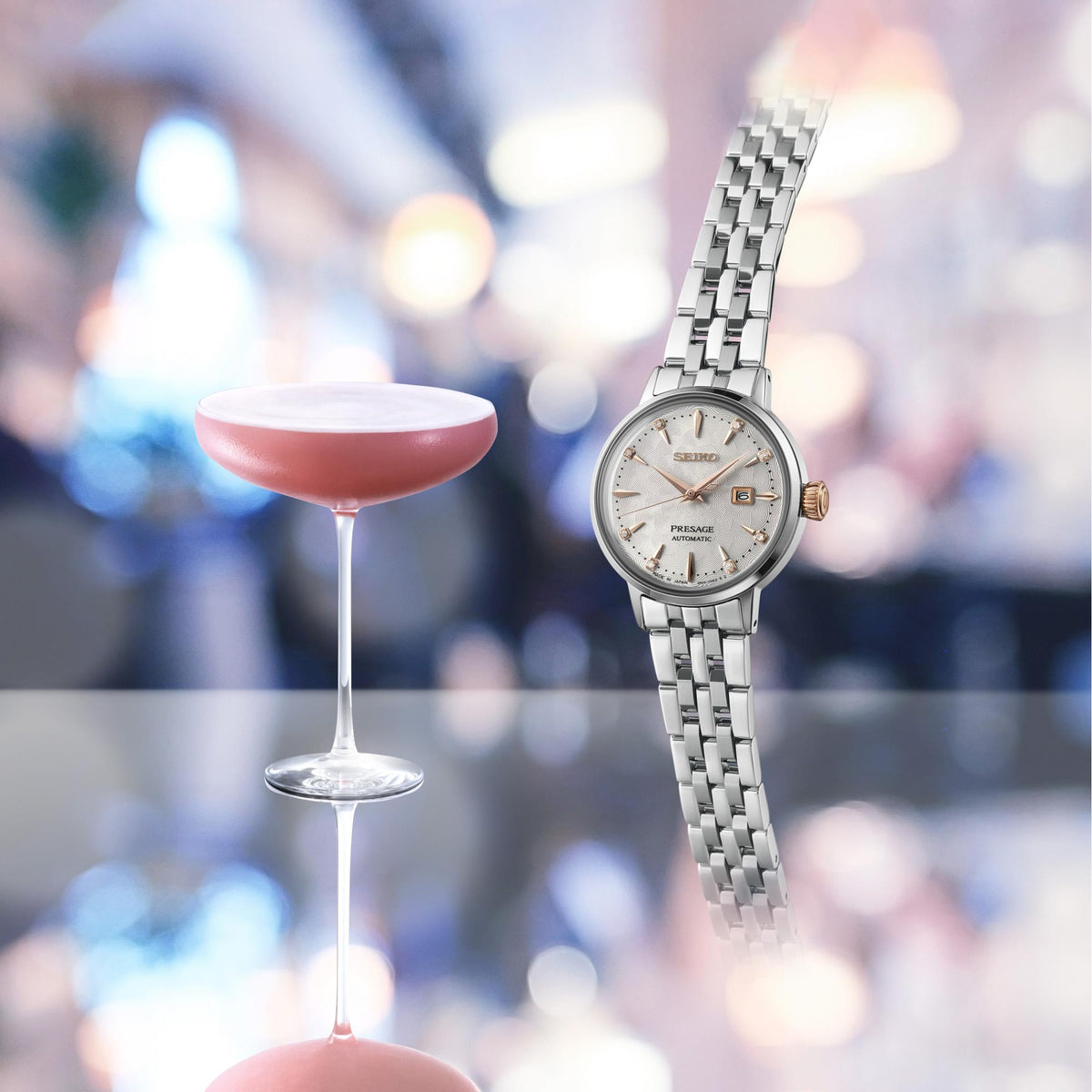Ladies steel wristwatch with white dial, gold markers, and rose-gold crown accents