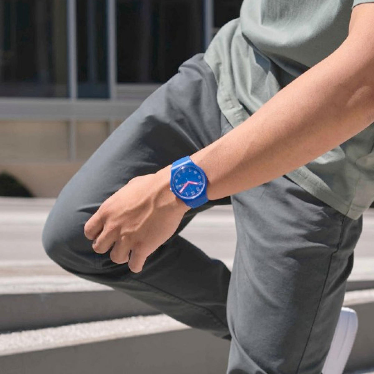 Swatch blue quartz watch on wrist, blue silicone band and date window
