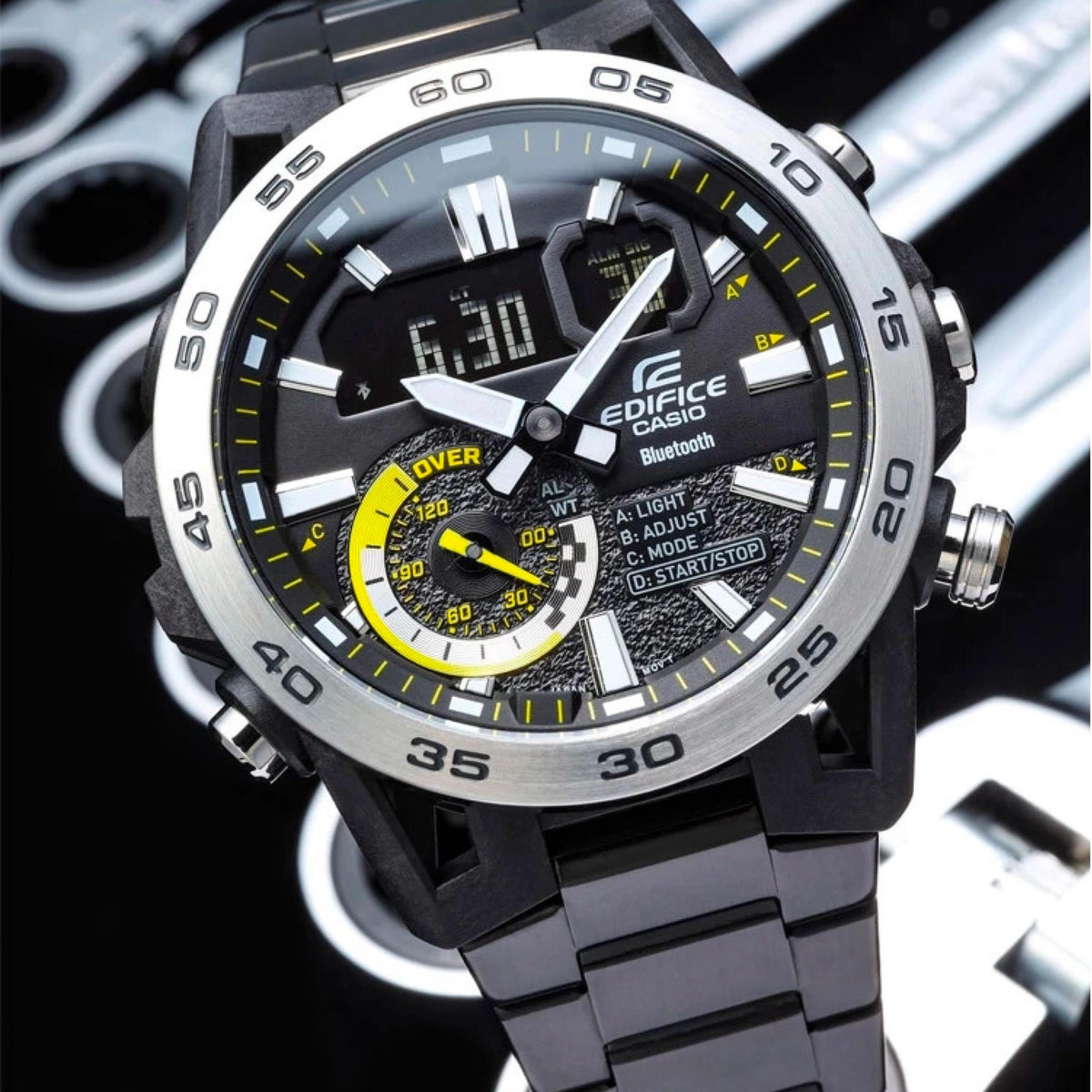Detailed view of mens Edifice watch dial with bezel scale, white hands, and yellow ring accents