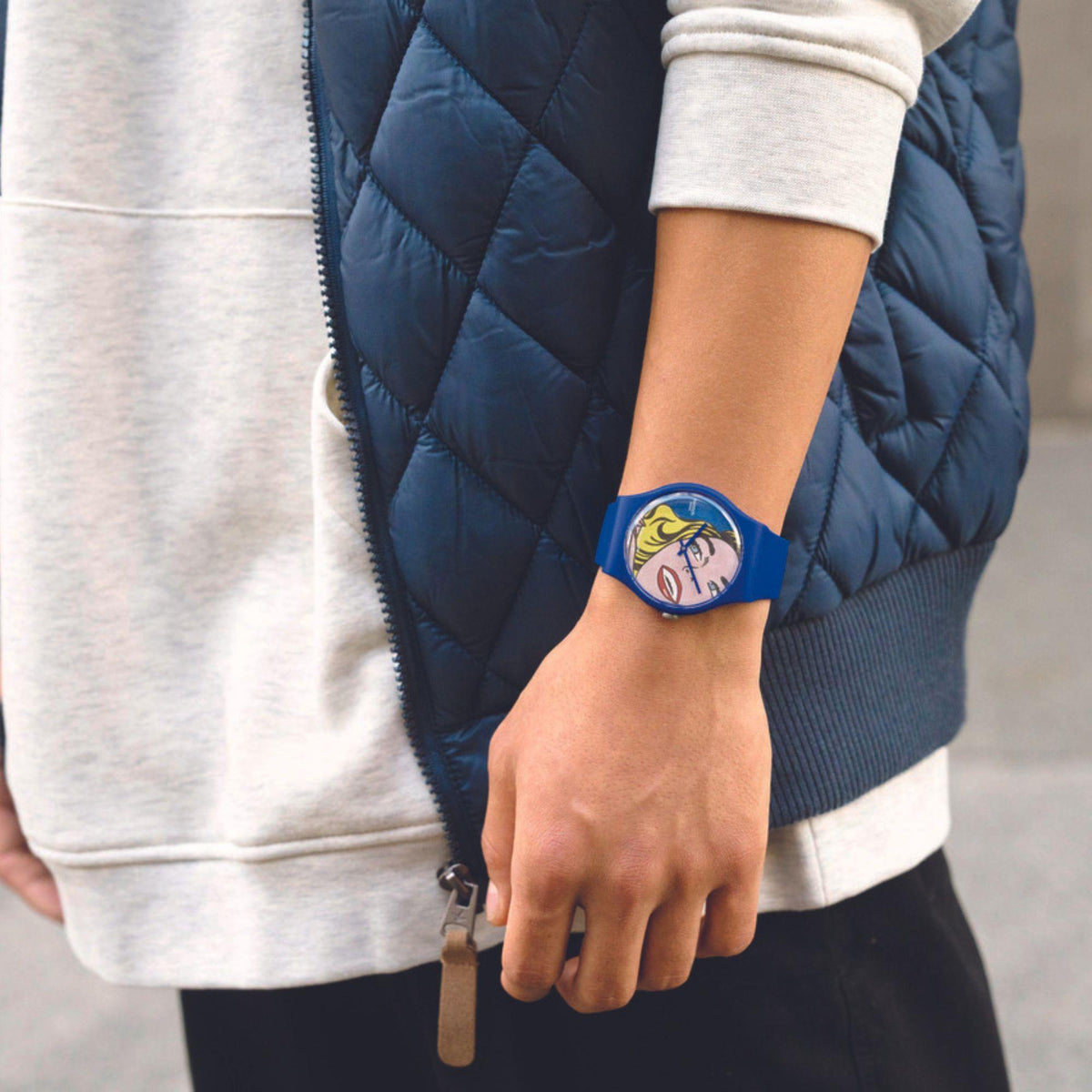 Blue silicone strap Swatch wristwatch on wrist with pop-art girl face dial