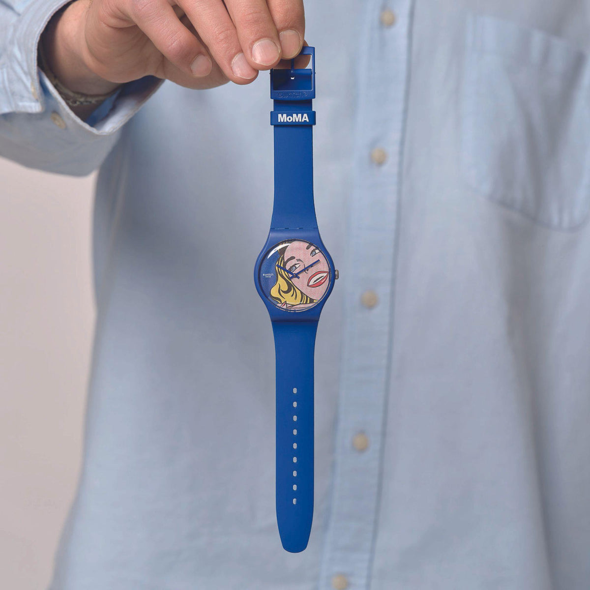 Blue silicone strap watch shown upright with comic portrait face