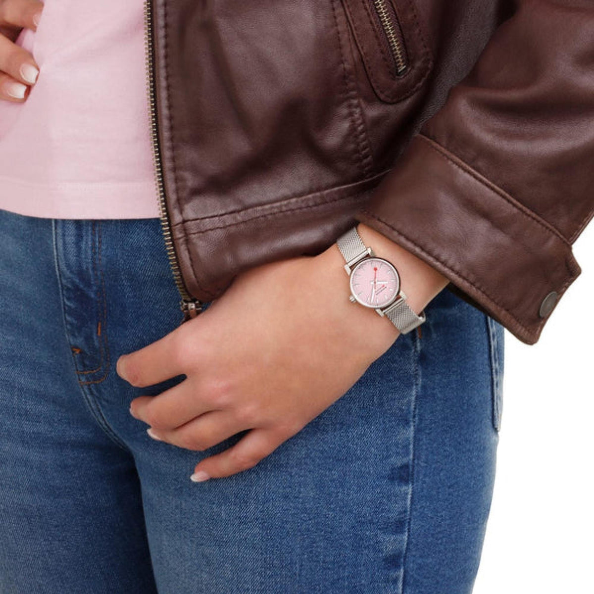 Women's steel mesh watch with pink dial on wrist, worn under jacket sleeve