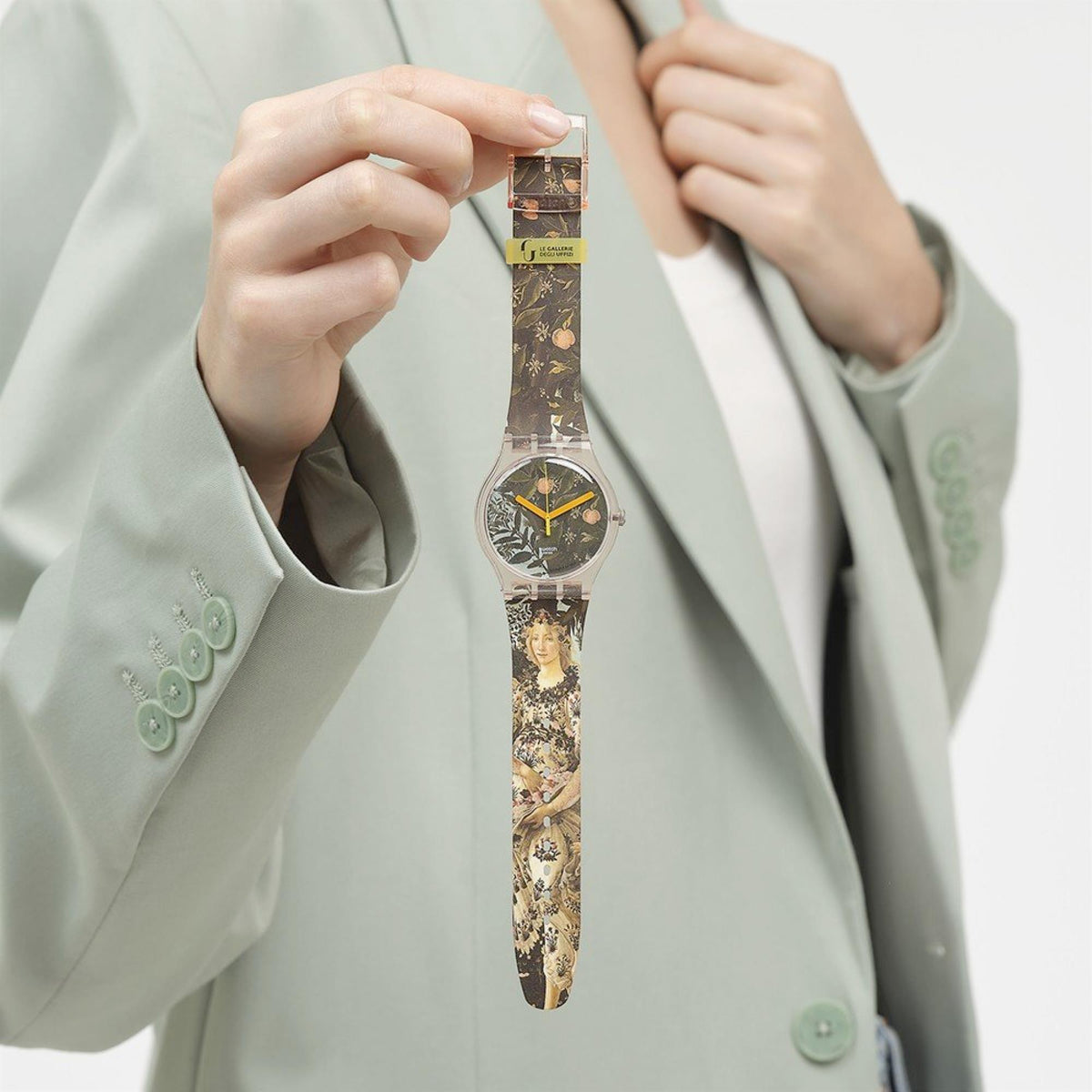 Quartz wristwatch with pink case, patterned brown-and-gold strap, orange hour markers