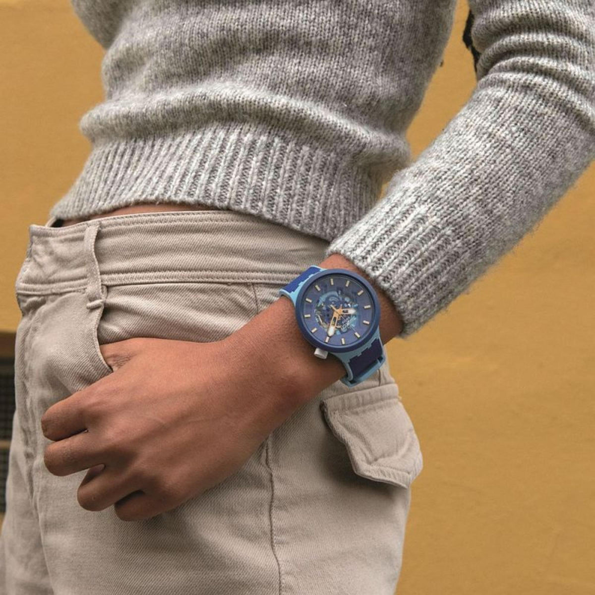 Blue dial Swatch Big Bold watch on wrist with dark-blue strap over light denim