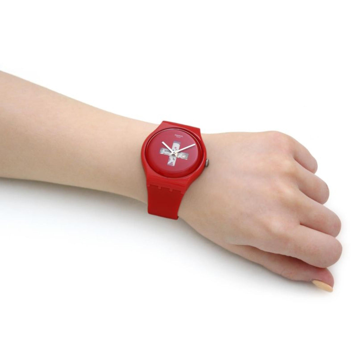 Red analog wristwatch on wrist, side view with round dial and red silicone strap