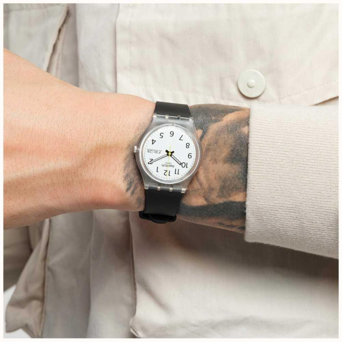 Black men’s wristwatch on wrist with white dial and date window at 4 o’clock