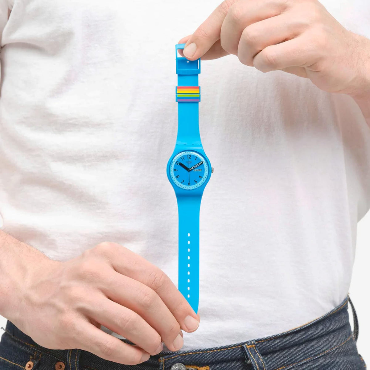 Blue quartz wristwatch on wrist with rainbow stripe detail and blue strap.
