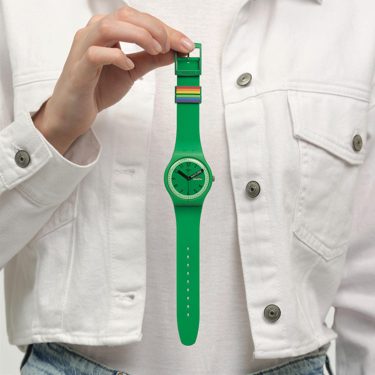Green quartz wristwatch on hand with green silicone strap and round dial
