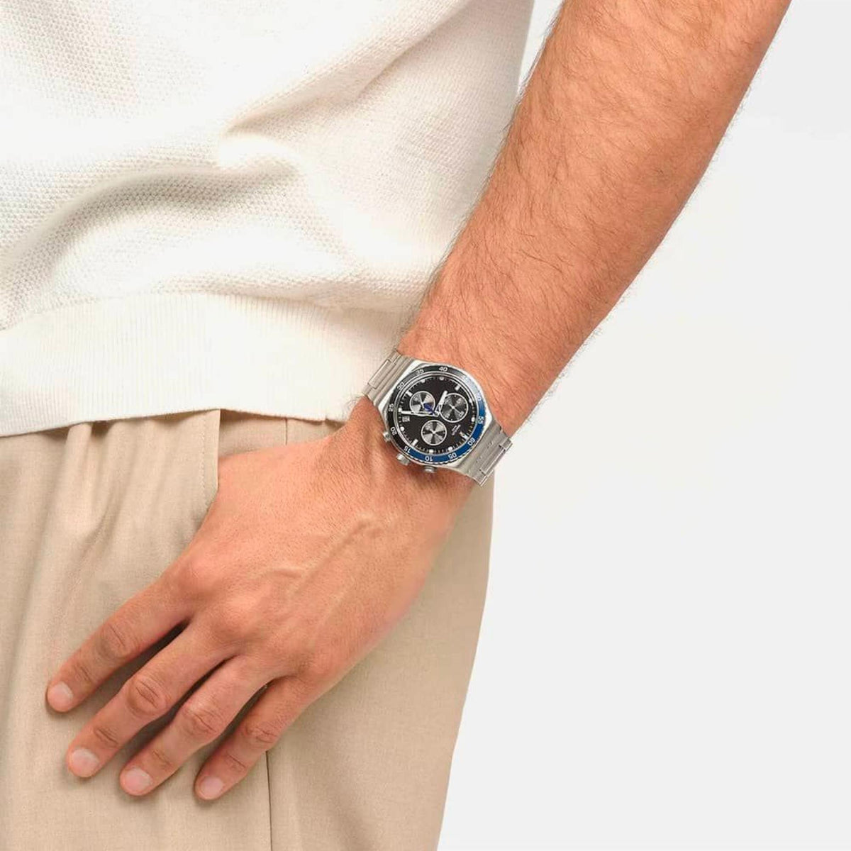 Chronograph wristwatch on wrist with silver bracelet, black dial, and blue bezel accents