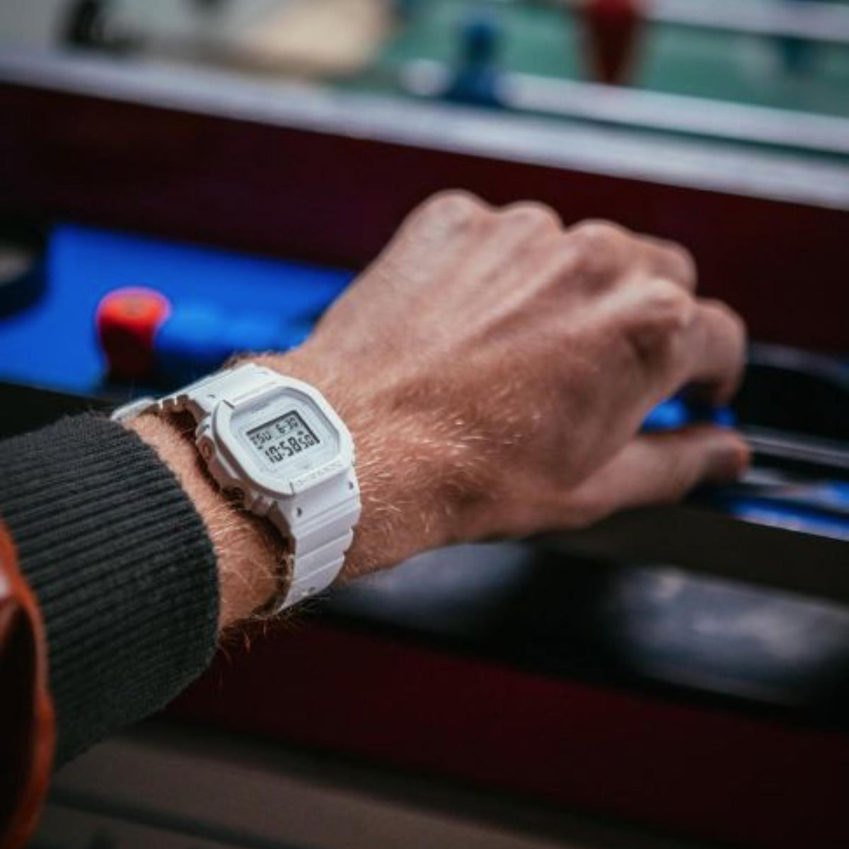 White resin strap Casio G-Shock digital watch worn on wrist, side view.