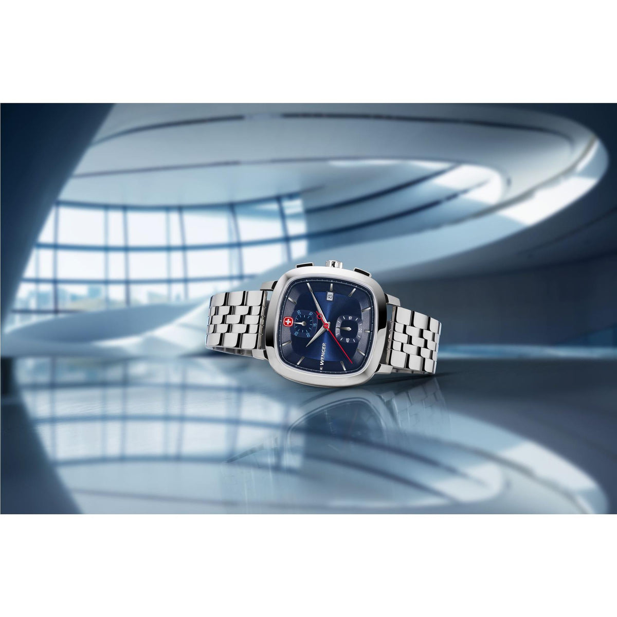Stainless steel bracelet watch on wrist, dark blue dial with red second hand and subdials