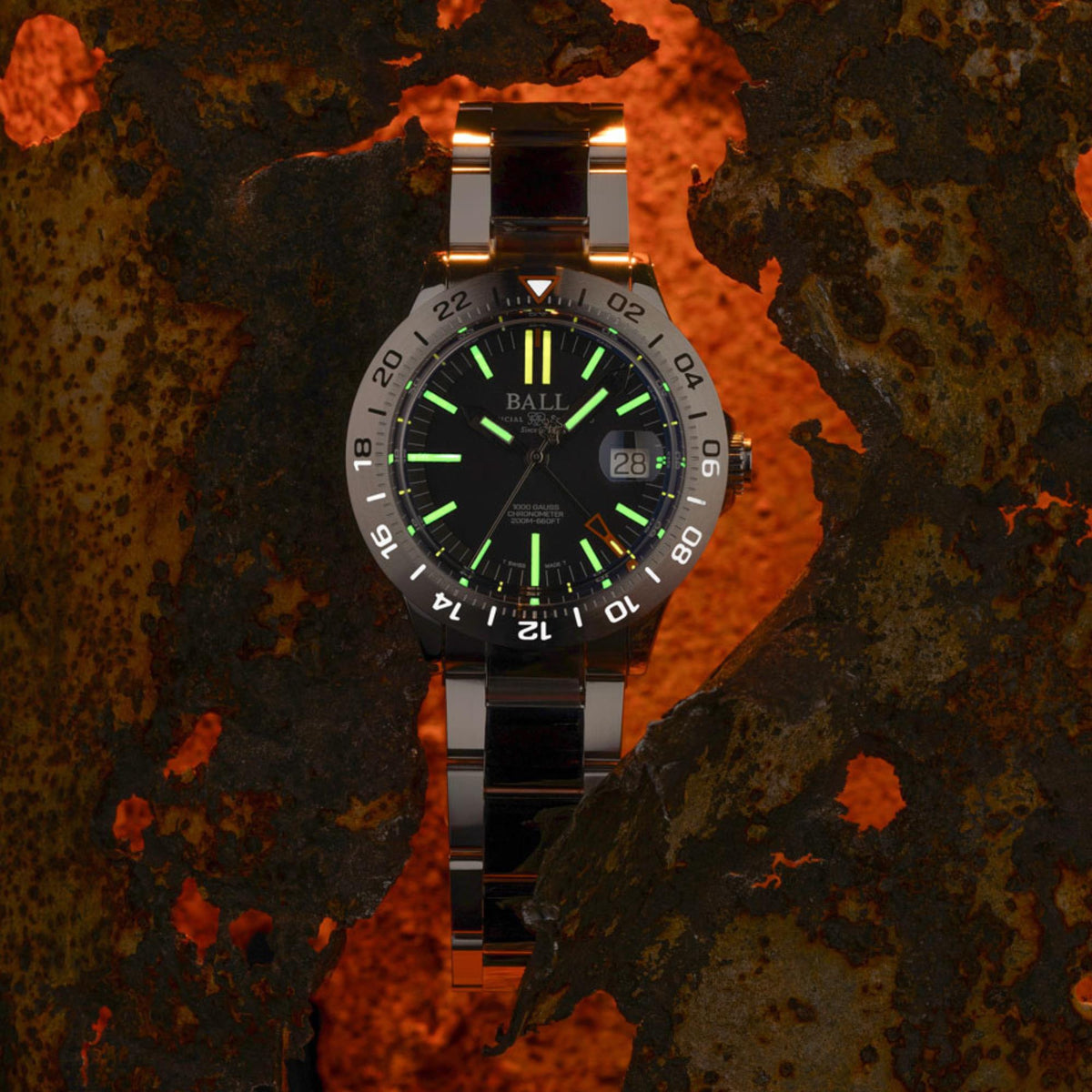 Men's stainless steel wristwatch with dark dial, green light markers, and date window at 28.