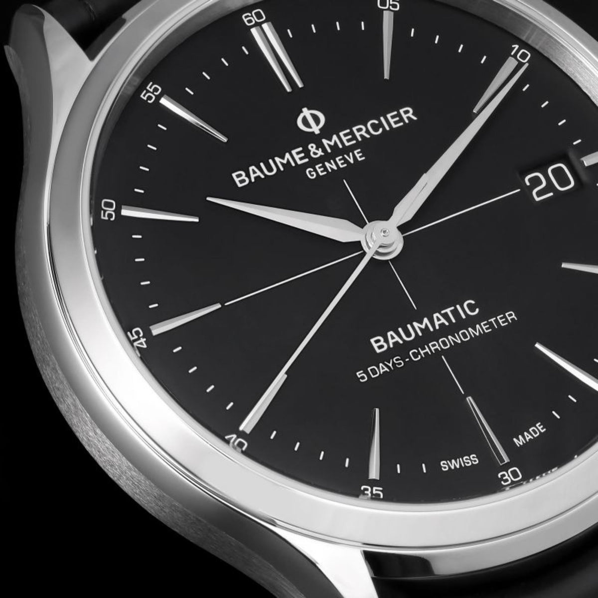Men's automatic wristwatch dial close-up: black face with hour markers and date.