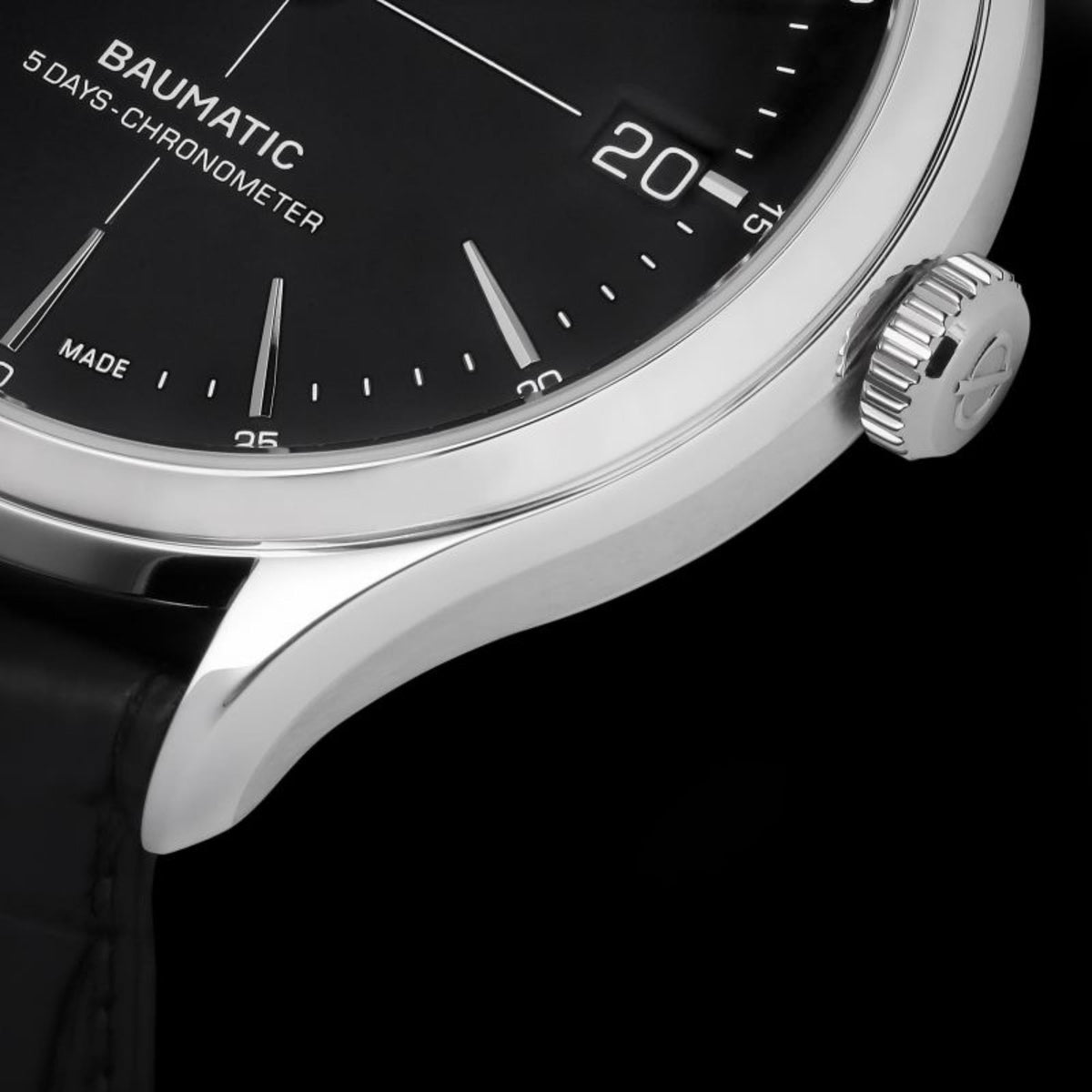 Men's automatic wristwatch close-up of crown and bezel beside the black dial.