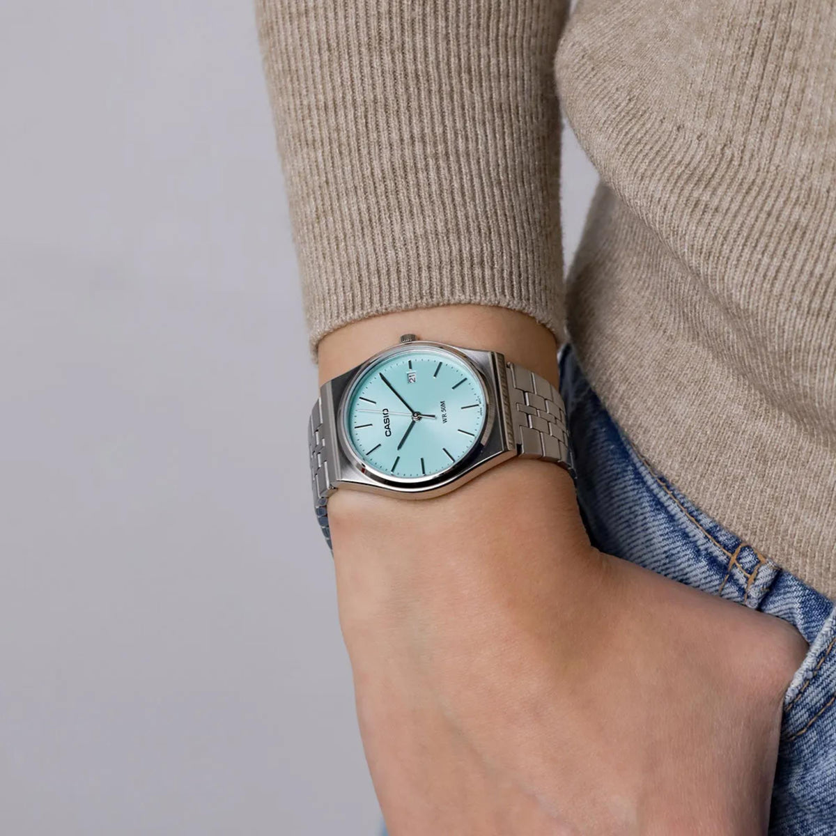 Casio quartz watch on wrist with light blue dial and stainless steel link bracelet