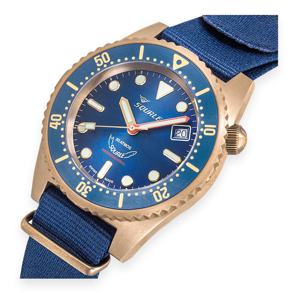 Men's bronze diver watch with blue dial and blue fabric strap, bezel detail close-up
