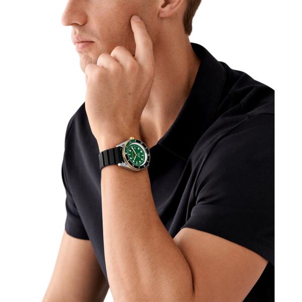 Men's green-dial watch on wrist with black silicone strap; silver case
