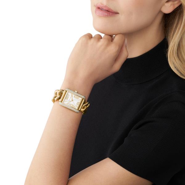 Gold-tone watch on model's wrist with white face and Roman numeral markers